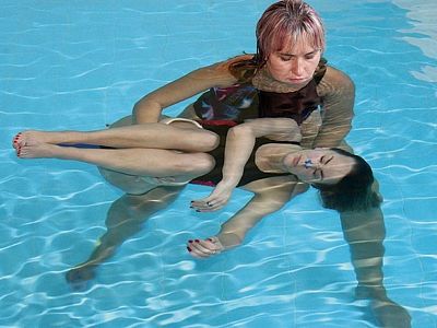 Terapeut dělá s klientem při aquahealingu různé uvolňovací a další cviky. 