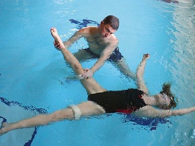 Terapeut dělá s klientem při aquahealingu různé uvolňovací a další cviky. 