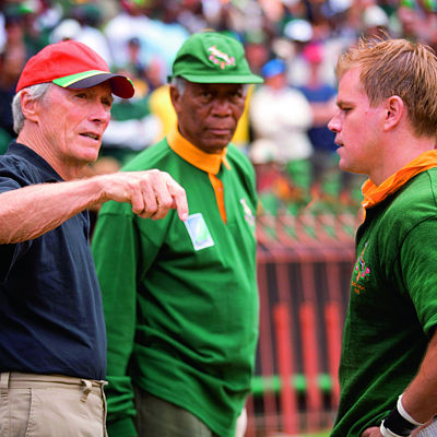  Při natáčení dramatu Invictus: Neporažený s režisérem Clintem Eastwoodem a hercem Morganem Freemanem. 