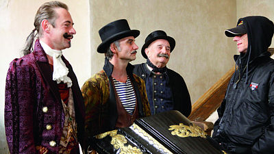 V další pohádce Jiřího Stracha (vpravo) Šťastný smolař dostal roli divokého Carlose (vlevo). S kolegy Ivanem Trojanem a Josem Somrem natáčeli mimo jiné na hradě Pernštejn.